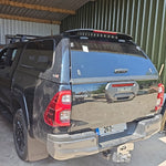Load image into Gallery viewer, A black Toyota Hilar pickup truck with a hardtop canopy SJS pop out windows.