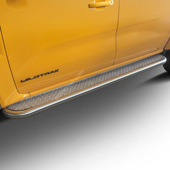 A close-up of a bright yellow Ford Wildtrak truck showing the side step protectors and running boards, with the 'WILDTRAK' badge visible on the rear door.
