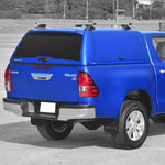 Load image into Gallery viewer, A Toyota Hilux double cab fitted with a Alpha CMX hardtop canopy, including side access gullwing doors, roof rails.
