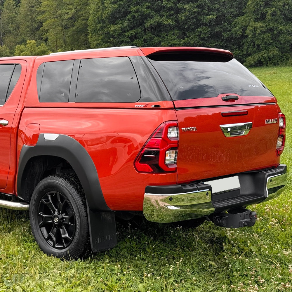A Toyota Hilux double cab fitted with a dark tinted pop-out style window hardtop canopy Alpha Type-E.